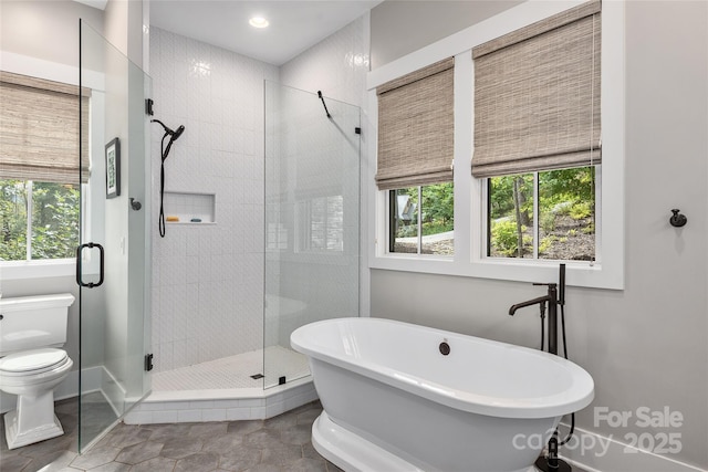 bathroom featuring toilet, tile patterned flooring, and shower with separate bathtub