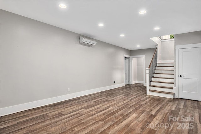 basement featuring hardwood / wood-style flooring and a wall unit AC