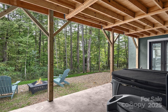 view of patio / terrace with a hot tub and a fire pit