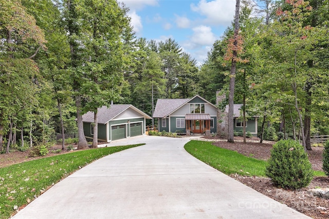 view of front of house with a garage, an outbuilding, and a front yard