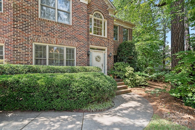 view of exterior entry featuring brick siding