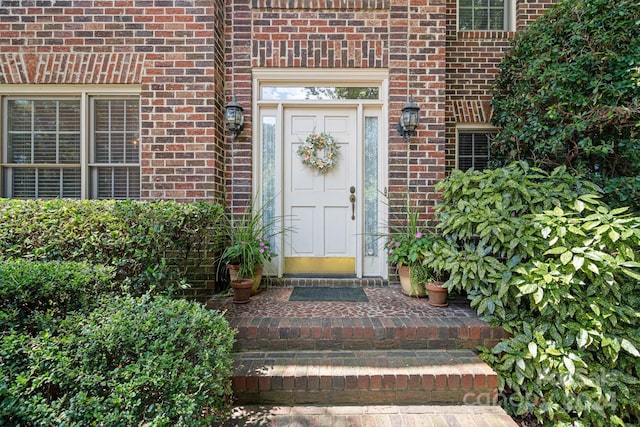 view of exterior entry featuring brick siding