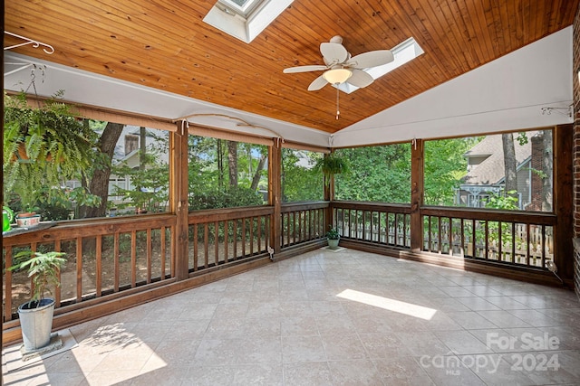 unfurnished sunroom with wood ceiling, ceiling fan, and vaulted ceiling with skylight