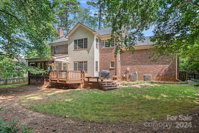 rear view of house featuring central AC unit, a lawn, and a wooden deck