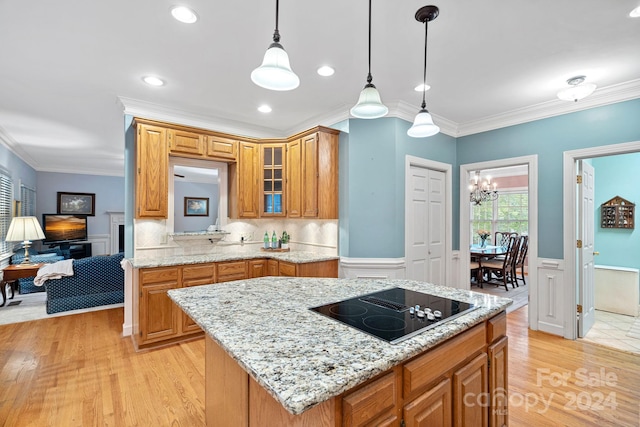 kitchen with light wood-type flooring, decorative light fixtures, a center island, and black electric cooktop