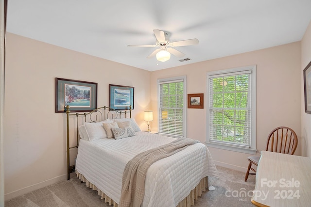 carpeted bedroom with multiple windows and ceiling fan