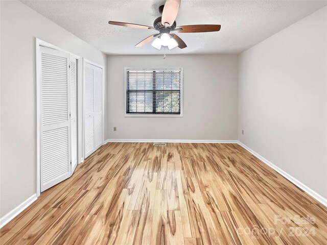 unfurnished bedroom featuring a textured ceiling, ceiling fan, and light hardwood / wood-style floors