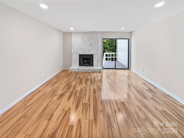 unfurnished living room featuring light wood-type flooring and a fireplace