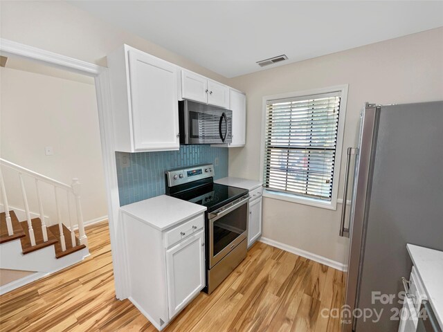 kitchen featuring light hardwood / wood-style flooring, stainless steel appliances, and white cabinetry