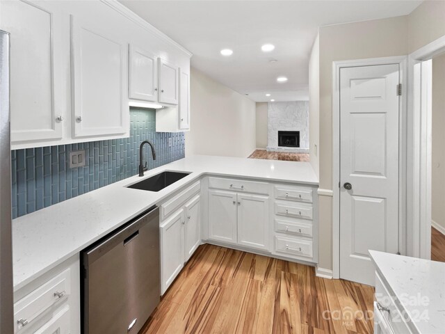 kitchen featuring white cabinets, dishwasher, light hardwood / wood-style floors, and sink