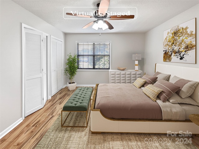 bedroom featuring light wood-type flooring, a textured ceiling, and ceiling fan