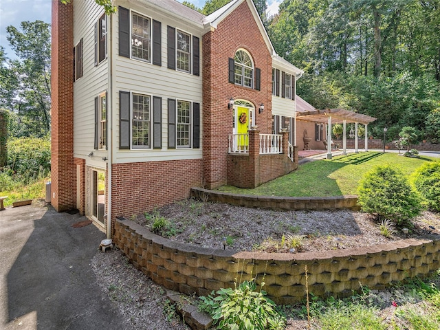 exterior space with a pergola and a front yard