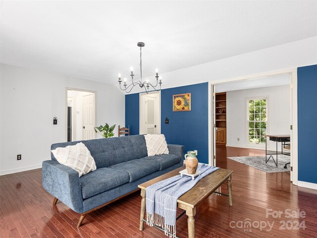 living room featuring an inviting chandelier and dark hardwood / wood-style flooring