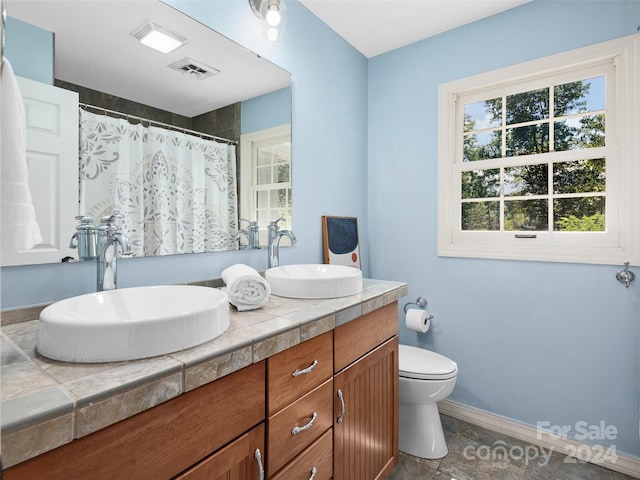 bathroom with vanity, toilet, and tile patterned floors