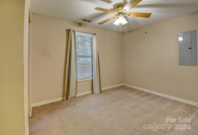 spare room with light carpet, electric panel, and ceiling fan