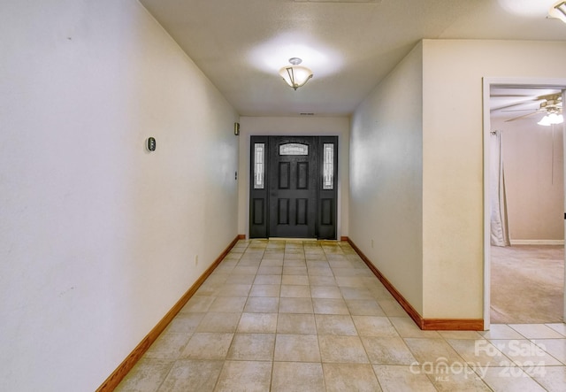 carpeted entryway with ceiling fan