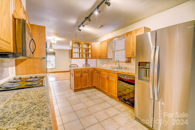 kitchen with light tile patterned floors, sink, black appliances, ceiling fan, and tasteful backsplash