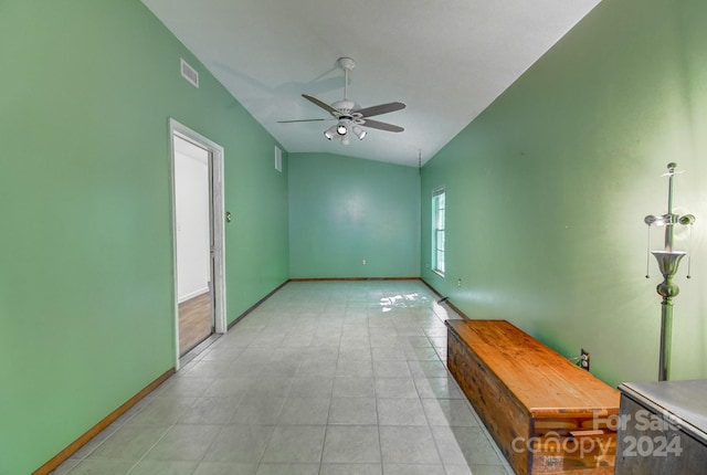 tiled empty room with lofted ceiling and ceiling fan