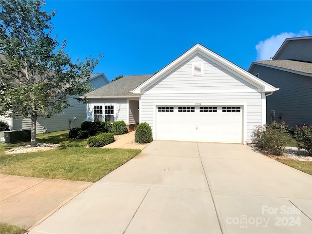 view of front of house featuring a garage, driveway, and a front yard