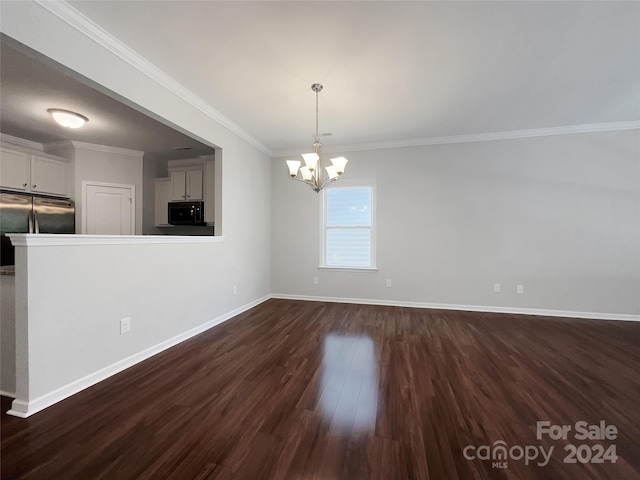 unfurnished dining area featuring ornamental molding, dark wood-style flooring, a notable chandelier, and baseboards