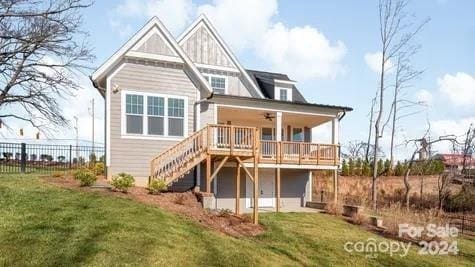 rear view of property featuring a lawn and ceiling fan