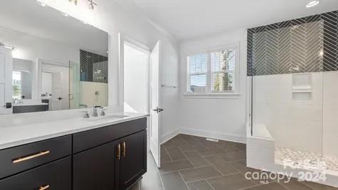 bathroom with vanity and a tile shower