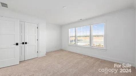 unfurnished bedroom with a closet and light colored carpet