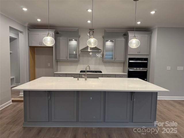 kitchen with gray cabinetry, hanging light fixtures, black double oven, and tasteful backsplash