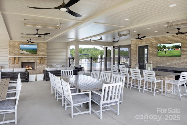 view of patio featuring ceiling fan and an outdoor living space with a fireplace