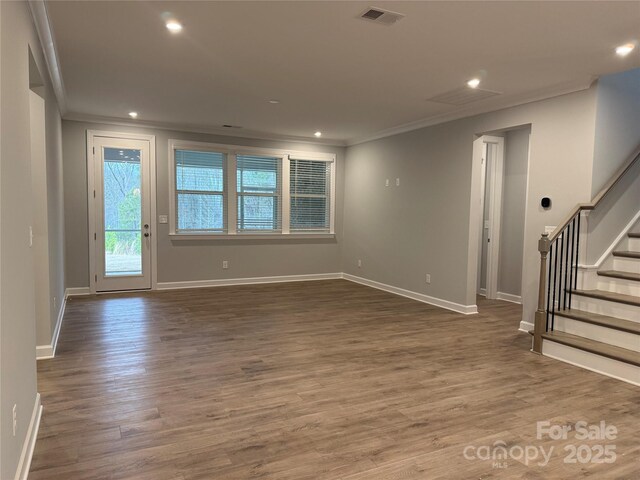 unfurnished living room with crown molding and dark hardwood / wood-style floors