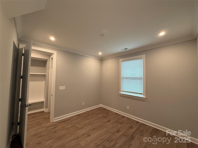 unfurnished bedroom featuring crown molding and dark hardwood / wood-style floors