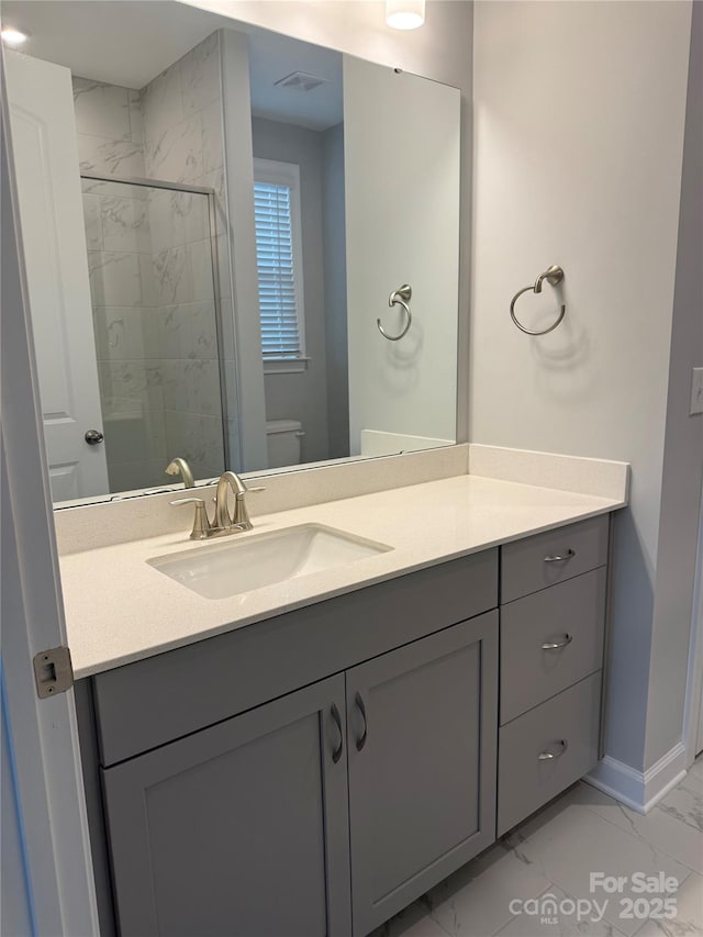 bathroom featuring toilet, a shower with door, and vanity