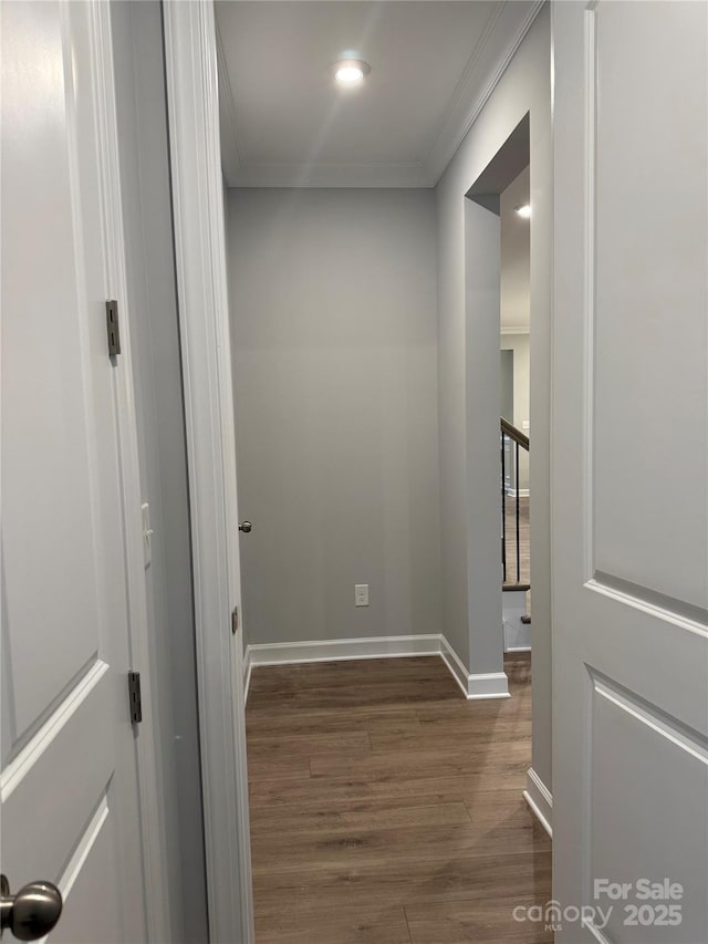 hallway with baseboards, dark wood-style floors, and ornamental molding