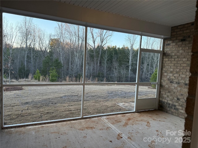 unfurnished sunroom featuring a view of trees