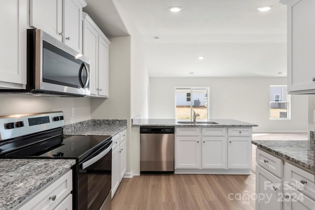 kitchen featuring white cabinets, appliances with stainless steel finishes, light hardwood / wood-style floors, and sink