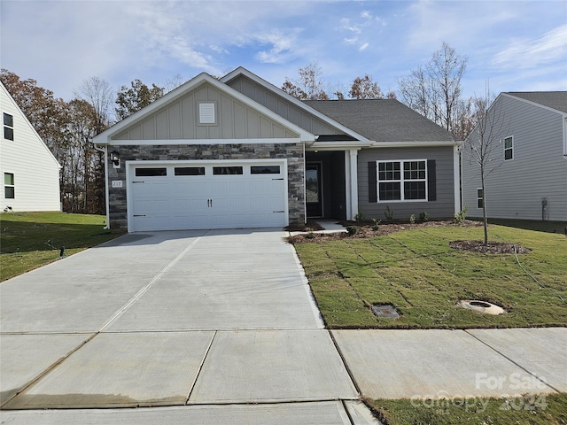 217 Colonial Reserve Ave, Troutman, NC 28166 - view of front of home with a front lawn, concrete driveway, an attached garage, and board and batten siding