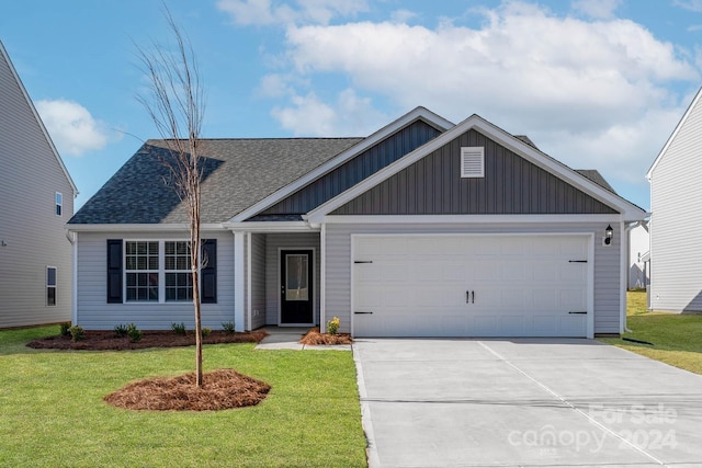 view of front of property featuring roof with shingles, board and batten siding, a front yard, a garage, and driveway