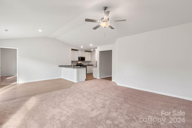 unfurnished living room with ceiling fan, sink, light carpet, and vaulted ceiling