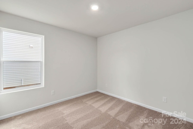 carpeted spare room featuring baseboards and recessed lighting