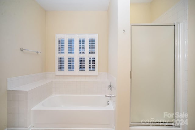 bathroom featuring separate shower and tub