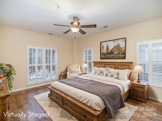 bedroom with dark hardwood / wood-style floors and ceiling fan