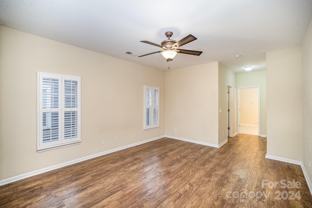 spare room featuring dark wood-type flooring and ceiling fan