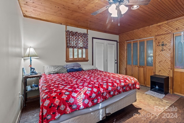 bedroom featuring wooden ceiling, wooden walls, ceiling fan, and wood finished floors