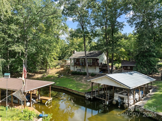 view of dock featuring boat lift, a water view, and a yard