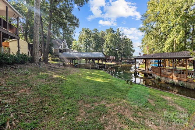 view of yard featuring a water view, boat lift, and a dock