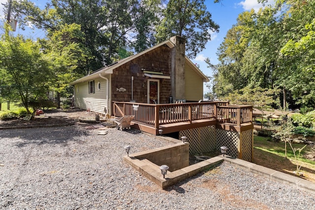 back of property featuring a chimney and a wooden deck