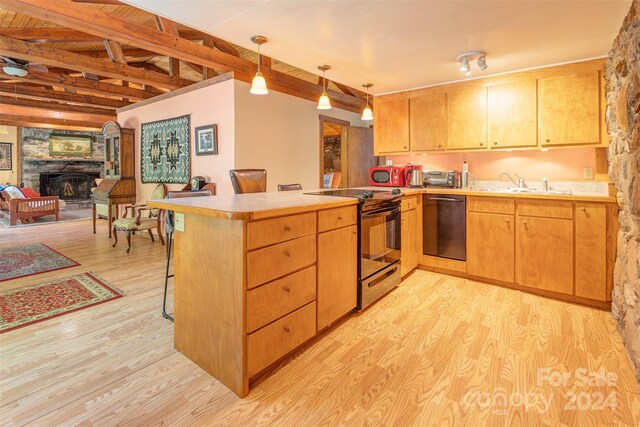 kitchen featuring a fireplace, dishwasher, light hardwood / wood-style flooring, hanging light fixtures, and electric range