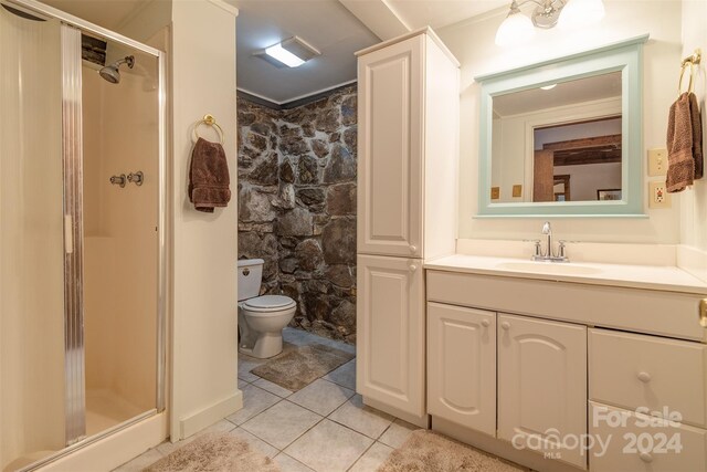 bathroom with vanity, toilet, walk in shower, and tile patterned floors