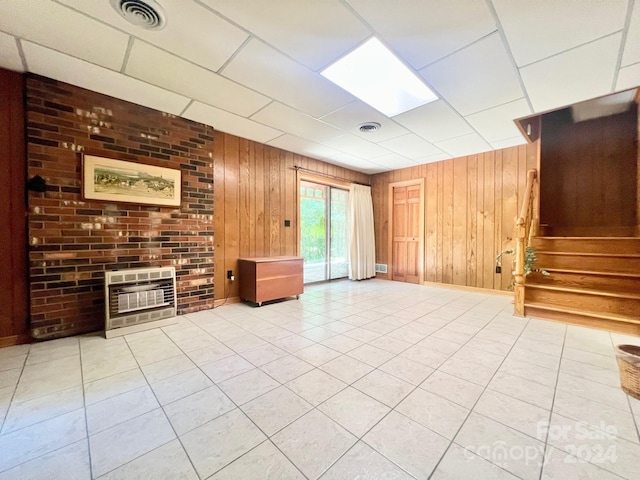 unfurnished living room with light tile patterned floors, stairway, visible vents, and heating unit