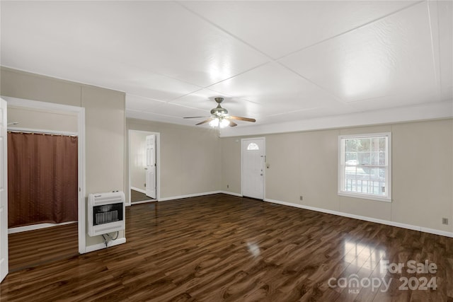 unfurnished living room featuring dark wood-type flooring, heating unit, and ceiling fan